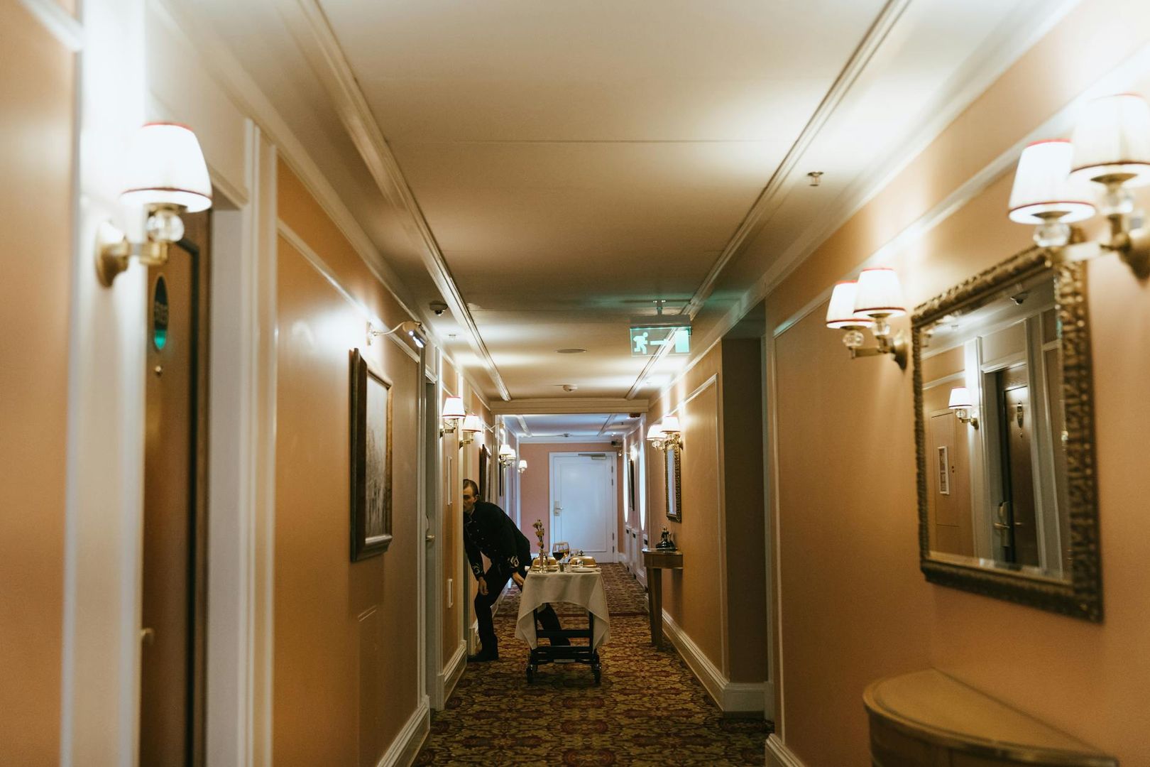 Hotellkorridor med en servicevagn och klassisk inredning.