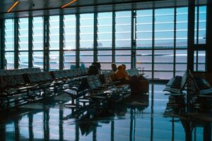 Resenärer väntar i flygplatsens avgångshall med bagage